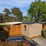 Terrasse en bois et bungalow beige dans un emplacement arboré au bungalow LUXE Koyobalys