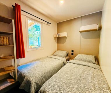 Chambre avec deux lits et rangements dans le chalet 3 bedroom Chalets Camping Leï Suves – JoyCasa