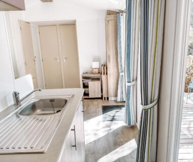 Coin cuisine et terrasse ouvrant sur l'extérieur dans le 3 bedroom Chalets Camping Leï Suves JoyCasa