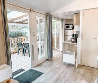 Intérieur avec kitchenette et terrasse en bois du 3 bedroom Chalets Camping Leï Suves JoyCasa