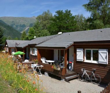 Terrasse de chalet avec chaises et vélo au camping A La Rencontre Du Soleil – Camping