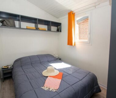 Chambre avec lit double et fenêtre ensoleillée au camping A La Rencontre Du Soleil