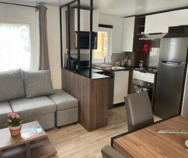 Intérieur séjour avec canapé et kitchenette du mobil-home A la brise du Ferret Camping les Embruns