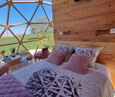 Intérieur de dôme avec lit et vue sur la campagne du camping A l'aube des sens