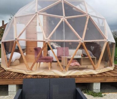 Terrasse avec dôme géodésique transparent et mobilier extérieur au camping A l'aube des sens