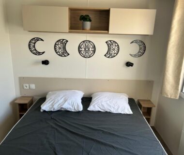 Chambre avec lit double et décorations murales lune et soleil dans l'AA-Luminosa