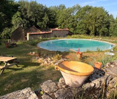Piscine ronde entourée d'herbe et de pierres au Domaine de Mombret Haut