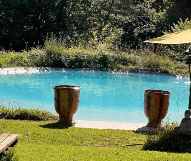 Bord de piscine avec pots et parasol au Domaine de Mombret Haut