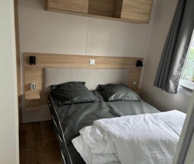 Chambre avec deux lits simples et tête de lit en bois dans l'Amira 6-8 personnes