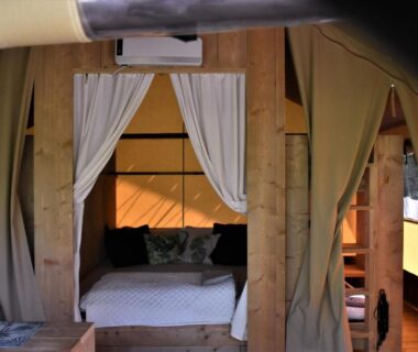 Intérieur de tente avec lit et rideaux au camping Analaya