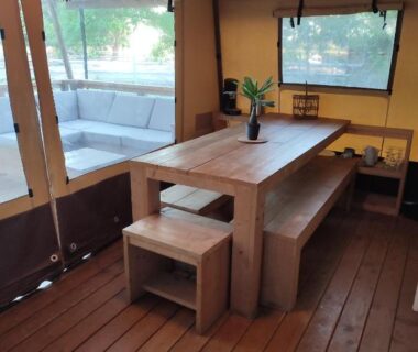 Intérieur de tente avec table en bois et banquette dans le camping Analaya