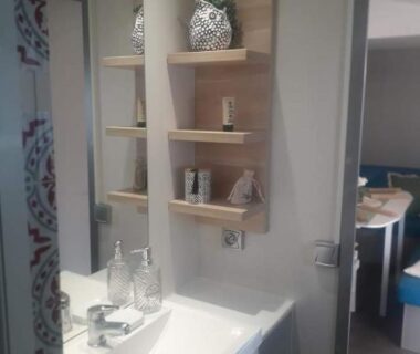 Salle de bains avec lavabo et étagères dans le logement d'Anne Marie