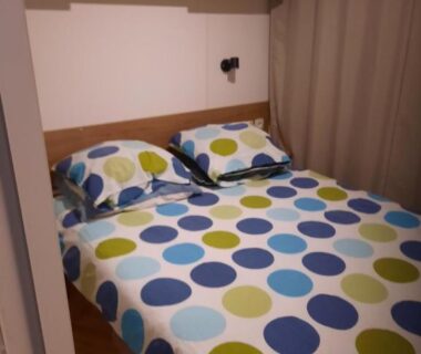 Chambre avec lit double et couette à pois au camping Aquapark -DESS