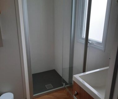 Salle de bain avec douche vitrée et lavabo du camping Aquapark -DESS