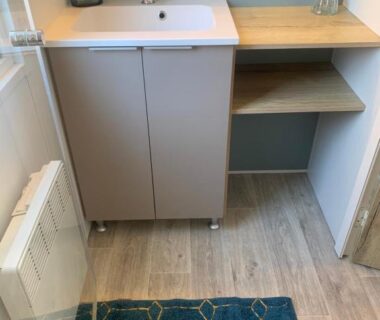 Salle de bain avec lavabo et plan de rangement au camping Au Petit Bonheur