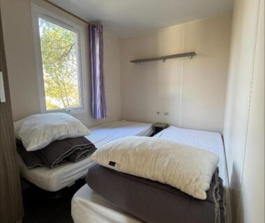 Chambre avec deux lits simples et fenêtre sur la pinède au camping Au coeur de la pinède