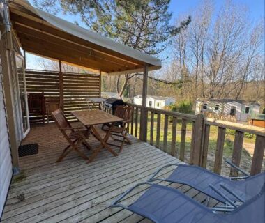 Terrasse en bois avec transats et table au camping Au coeur de la pinède
