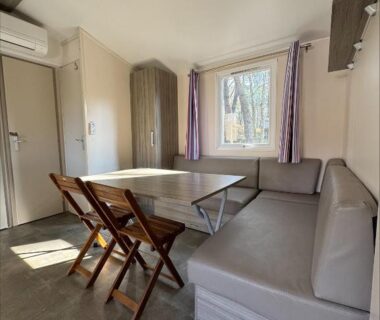 Intérieur coin repas avec banquette et table de l'hébergement Au coeur de la pinède