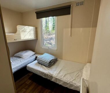 Chambre avec lits superposés et lit simple dans l'hébergement Au cœur des Pins