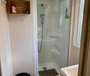 Salle d'eau avec cabine de douche et vasque dans l'hébergement Au cœur des Pins