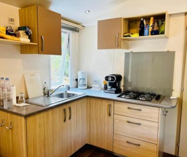 Coin cuisine avec évier plaque cuisson et cafetière dans le logement Au cœur des Pins
