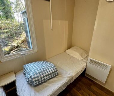Chambre avec lit simple et fenêtre au camping Au cœur des Pins