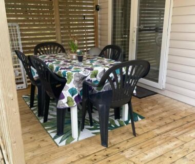 Terrasse couverte avec table et chaises du logement Au petit paradis