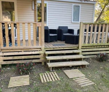 Terrasse en bois avec salon extérieur devant mobil-home au camping Au petit paradis