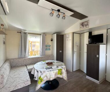 Séjour avec banquette table et télévision dans le mobilhome Au p’tit bonheur
