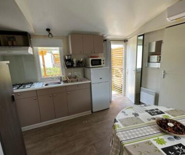 Intérieur avec kitchenette et coin repas dans le logement Au p’tit bonheur