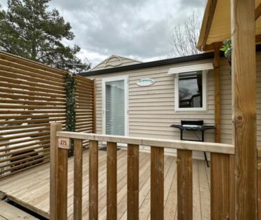 Terrasse en bois avec barbecue devant mobil home au camping Au p’tit bonheur