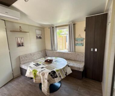 Coin repas avec banquette et table dans le mobil-home Au p'tit bonheur