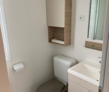 Salle de bains avec WC lavabo miroir et rangements dans le bungalow Au viviers camping Siblu sublime