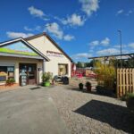 Façade et entrée du camping avec parking et jardinières aux Cygnes D'Opale