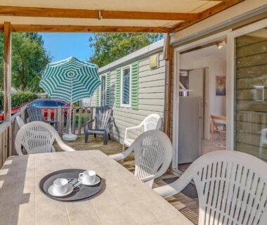 Terrasse avec table chaises et parasol de l'Awesome Stacaravan In Saint-Georges-De-Didon