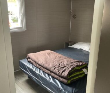 Chambre compacte avec lit et rangements dans l'hébergement Azur Premium Climatisé au camping la presqu'île du Barcarés