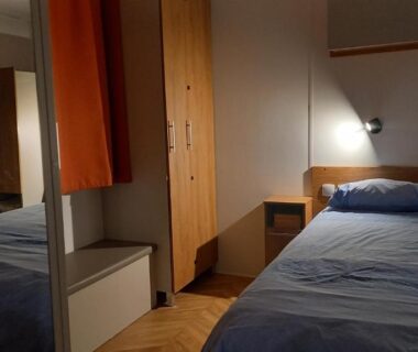 Intérieur de chambre avec lit double et armoire au camping Azur072