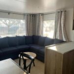 Intérieur salon avec canapé d'angle et table basse dans l'hébergement BT - Le Soleia