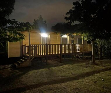 Terrasse éclairée d'un mobil-home la nuit au camping BT Le Soleia