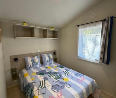Chambre avec lit double et petite fenêtre au camping Bahia