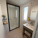 Salle d'eau avec douche vitrée et lavabo du camping Bahia