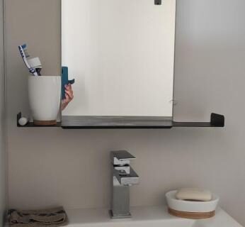 Salle de bains avec lavabo miroir et accessoires de toilette dans le Baia 1