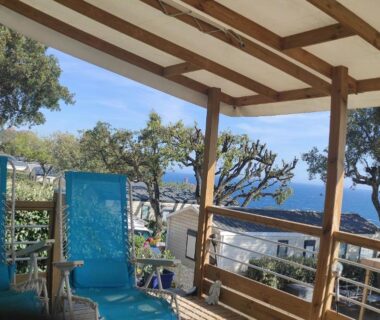 Terrasse ombragée avec transats et vue mer au Baia 1