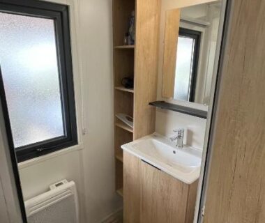Salle de bains compacte avec lavabo miroir et fenêtre dans le camping Bayaïna