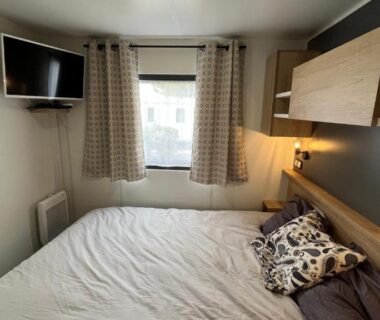Chambre avec lit double et télévision dans le mobil-home Bayaïna