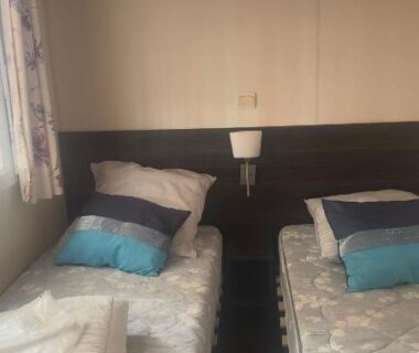 Chambre avec deux lits jumeaux et serviettes pliées dans le Beau Mobilhome 6 à 8p tout confort