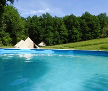 Piscine et tentes au bord du bois au Belair le Camping