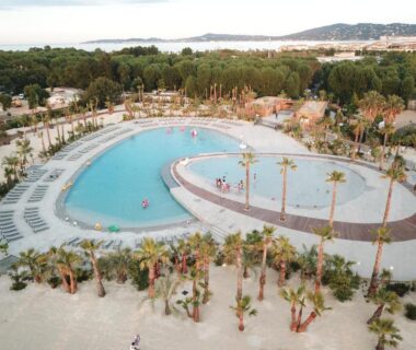Lagon de piscine entouré de palmiers et transats au Best Holiday Port Grimaud