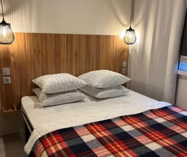 Chambre avec lit double et plaid à carreaux au Best Holiday Port Grimaud