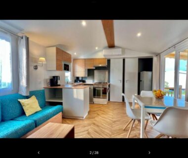 Intérieur du logement avec canapé turquoise et cuisine ouverte au Bien dans le sud